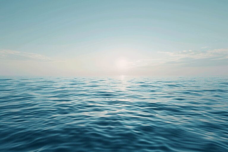A calm ocean horizon under a wide open sky with gentle waves